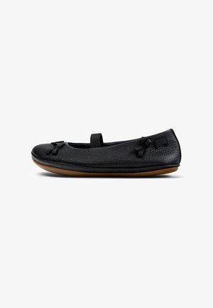 Ballerines noires en cuir avec une finition texturée, une lanière sur le cou-de-pied et deux petits nœuds sur le bout. Semelle en caoutchouc avec une teinte marron clair.