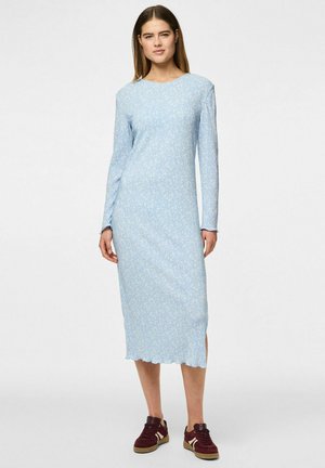 Hellblaues, langärmliges Kleid mit kleinem weißen Blumenmuster, knielang, gerippte Textur und gewelltem Saum; getragen mit dunkelroten Sneakers.