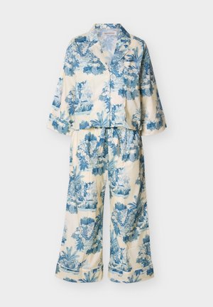 Ensemble de pyjama deux pièces avec haut à manches longues boutonné et pantalon ample à larges jambes, tissu crème avec imprimé floral et feuillage bleu.