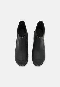 Black ankle boots with a smooth leather upper, elastic side panels, and a textured rubber sole for grip. Simple, modern design.