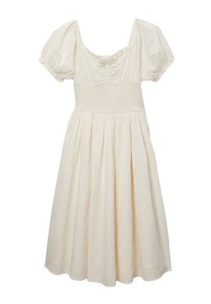 Robe midi couleur crème avec manches bouffantes, encolure carrée, taille smockée, petit détail de nœud et motif brodé subtil.