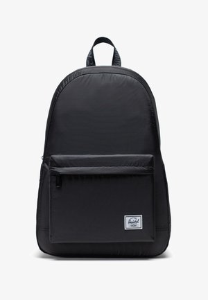 Sac à dos noir en tissu durable avec une forme arrondie, doté d'une poche zippée à l'avant, d'un patch logo et de bretelles réglables.