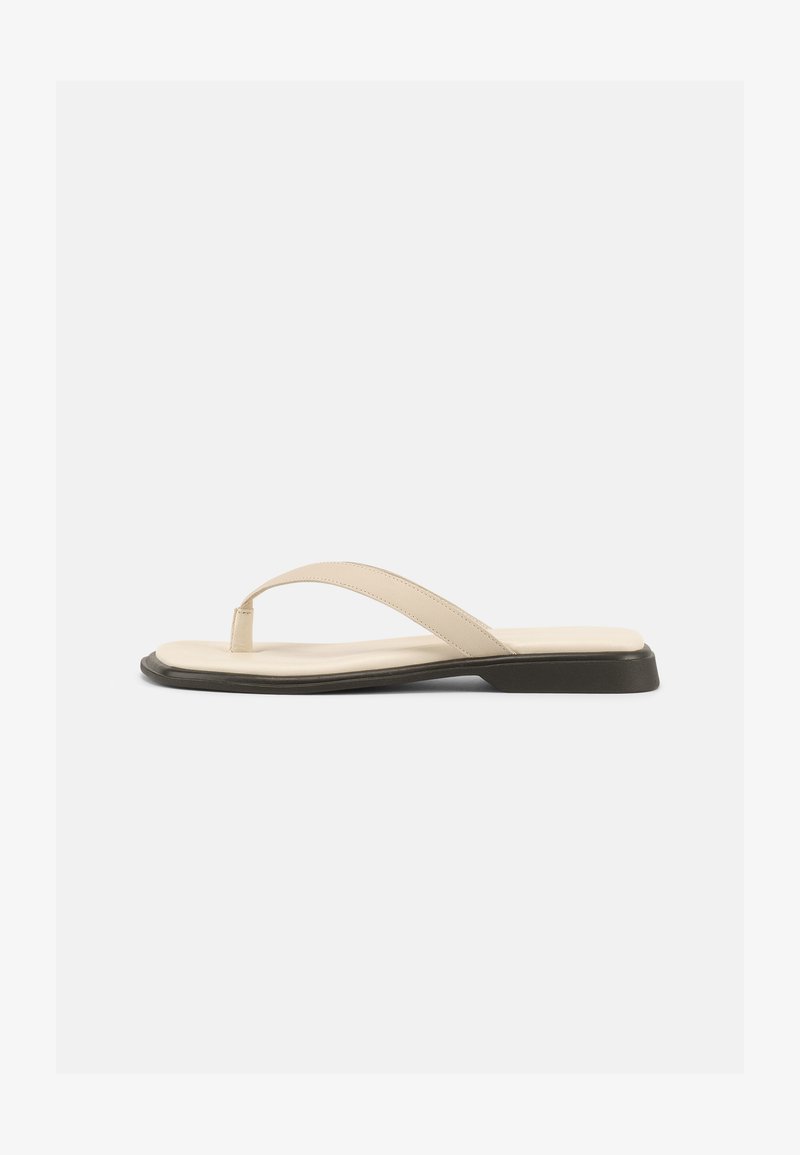 Μπεζ επίπεδη σαγιονάρα με επενδεδυμένο πέλμα και μαύρη σόλα, εμφανιζόμενη από το πλάι σε λευκό φόντο.