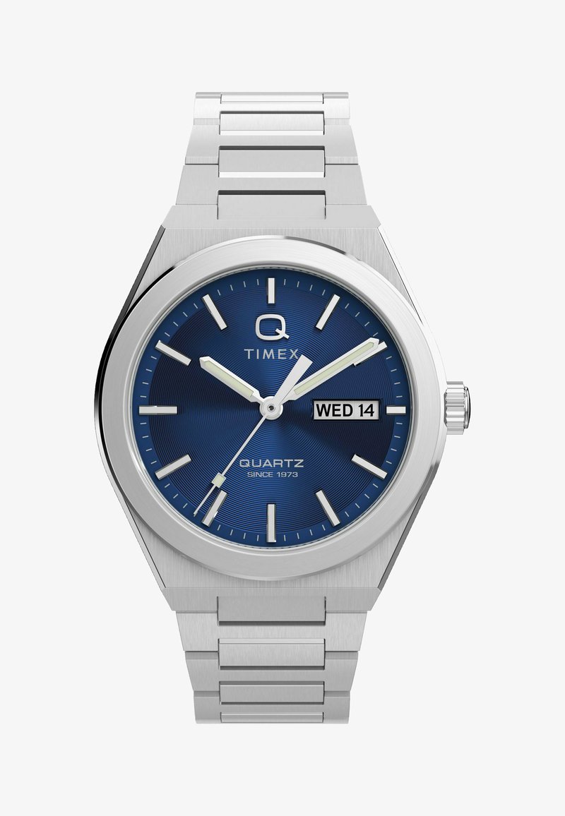 Sølv Timex ure med blå urskive, sølv timeindekser, lysende visere, sekundviser og dato-visning der viser "ONS 14".
