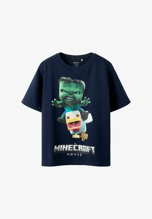 T-shirt en coton bleu marine avec un graphique d'un personnage vert les bras levés et un canard jaune, avec le texte "MINECRAFT MOVIE" en dessous.