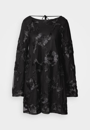 Crna haljina s dugim rukavima, ukrašena cvjetnim vezom, zaobljenim izrezom i vezanjem na leđima. Prozirni materijal s opuštenim krojem.