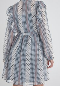 Abito leggero e a fantasia con maniche a volant, caratterizzato da strisce alternate blu, crema e rosa, vita cinchata e una silhouette fluente.