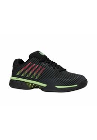 Baskets de sport noires avec un dessus texturé, des accents verts et des rayures colorées. Elles disposent d'une semelle rembourrée et d'un design bas.