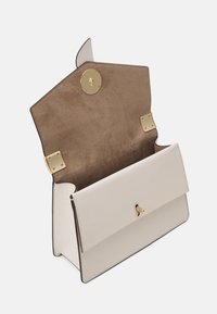 Borsa a tracolla in pelle beige con patta aperta che mostra l'interno in suede marrone e chiusura a morsetto dorato con dettagli hardware.