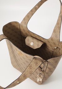 Bruine tas met patroon, gemaakt van gestructureerd synthetisch materiaal; voorzien van een druksluiting, logo-detail en accenten in goudkleurige hardware.