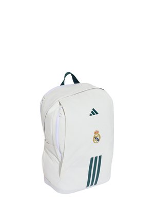 Hvid rygsæk med mørkegrønt Adidas-logo, tre striber og Real Madrid fodboldklubs våbenskjold på den forreste lomme.