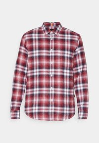 Chemise à manches longues rouge, noire et blanche avec boutons, motif à carreaux et poche poitrine, présentée sur un fond clair.