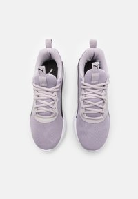 Lila lätta träningsskor med ovandel i nät, platta snören och en strukturerad sula, med en svart accent och logotyp på tungan.
