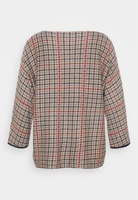 Striktop med et beige houndstooth mønster, prydet med røde og sorte striber. Løs pasform med trekvartærmer og rund halsudskæring.