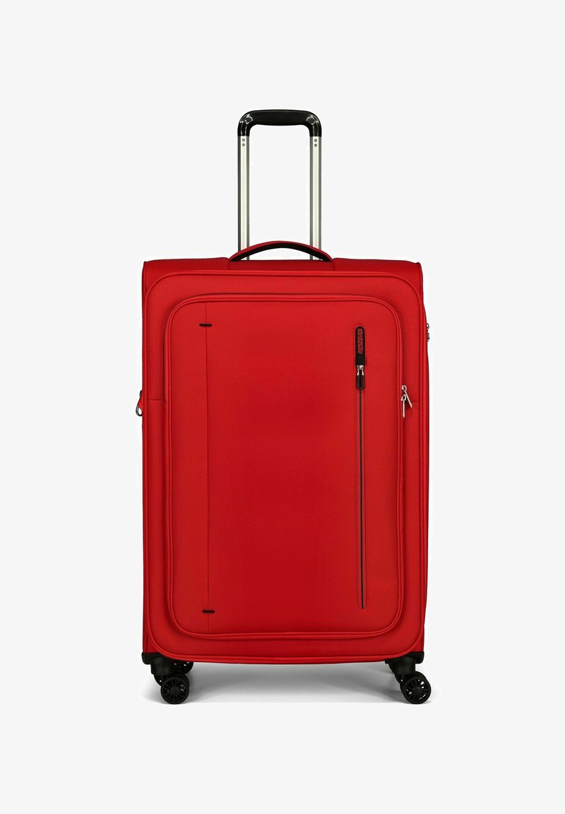 Valise rigide rouge avec une poignée en aluminium robuste, des roues à roulement fluide, une poche zippée à l'avant et une surface texturée.