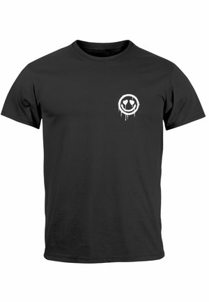 Black cotton t-shirt featuring a small white spray paint-style smiley face with heart eyes on the left chest area. Short sleeves, crew neck.