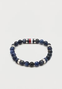 Ελαστικό βραχιόλι με στρογγυλές χάντρες από σκούρο μπλε λίθο και ασημένιες λεπτομέρειες, που διαθέτει κυλινδρική χάντρα με κόκκινες, λευκές και μαύρες ρίγες.