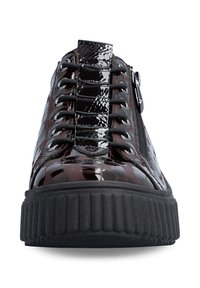 Vue de face d'une basket plateforme sombre et brillante avec une semelle épaisse noire, une fermeture éclair latérale et une tige texturée brillante avec des lacets noirs.