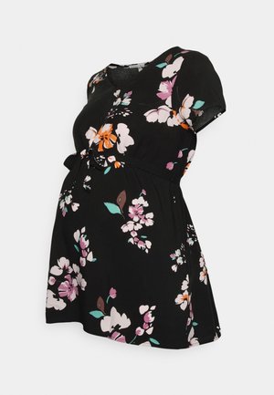 Zwarte zwangerschapsjurk met korte mouwen, bloemenprint in roze, wit, oranje en groen, en een gestrikt taille detail.