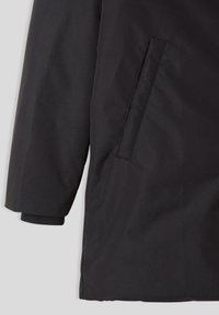 Giacca nera impermeabile con maniche lunghe, dotata di tasca laterale e polsini a coste. Tessuto liscio, design minimalista senza motivi visibili.