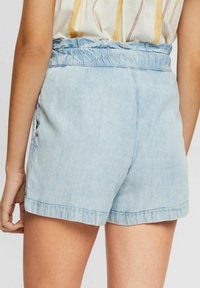 Light blue denim shorts with an elastic waistband, featuring a relaxed fit and rolled hem. Smooth texture and simple design details.