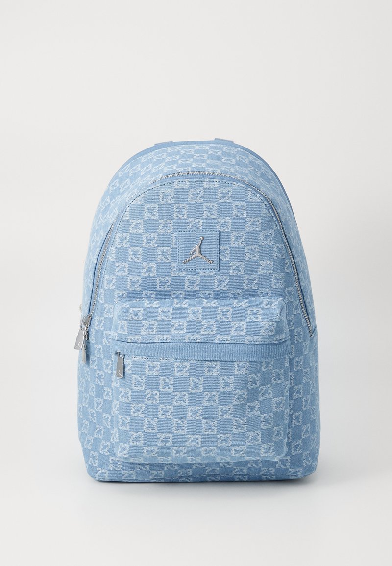 Light blue backpack with a textured checkered pattern, featuring a silver logo patch and dual zipper front pocket.