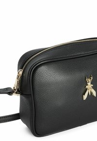 Borsa a tracolla nera in pelle con finitura testurizzata, hardware dorato e un accento a forma di ape sulla parte anteriore. Presenta una chiusura con zip.