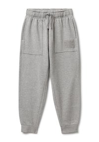 Hellgraue Trainingshose mit elastischem Bund, Kordelzug, großen Fronttaschen, Bündchen an den Knöcheln und einem kleinen Textpatch auf der rechten Tasche.