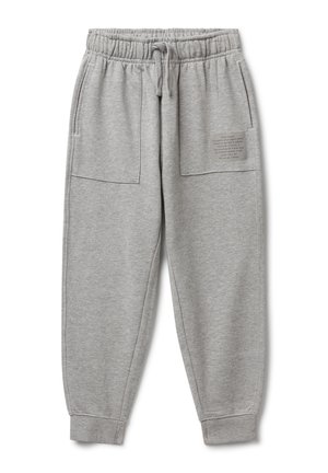 Hellgraue Trainingshose mit elastischem Bund, Kordelzug, großen Fronttaschen, Bündchen an den Knöcheln und einem kleinen Textpatch auf der rechten Tasche.