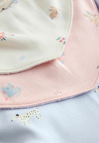 Bavoirs en tissu de coton doux ; rose pastel et crème avec des imprimés d'animaux. Bords festonnés ; couture contrastante ; accent de fond bleu clair.