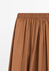 Jupe marron avec taille élastique froncée et tissu doux et fluide sur fond blanc uni.
