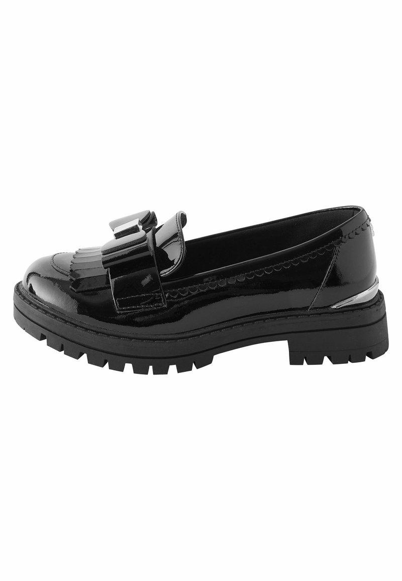 Svart lackläderloafersko med en dekorativ rosett, featuring en klumpig sula och räfflad mönstring för grepp. Förstärkt sömnad betonar designen.