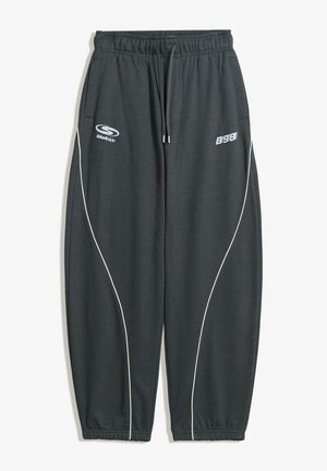 Tamno sive trenerice s opuštenim krojem, elastičnim pojasom, vezicom, bijelim bočnim trakama i logotipom s prednje strane.