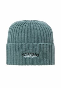 Strikket hue i teal med lodret ribbet tekstur. Har broderet tekst i sort og hvid. Blødt materiale, tætsiddende design.