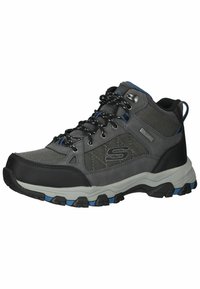 Zapatilla de senderismo gris con paneles de malla, puntera reforzada, suela de goma negra, acentos azules y un sistema de cordones resistente para mayor soporte.