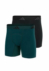 Twee paar herenboxershorts; één in donkerzwart, de ander in groen. Beide hebben een elastische tailleband met merknaam en opvallende strepen.