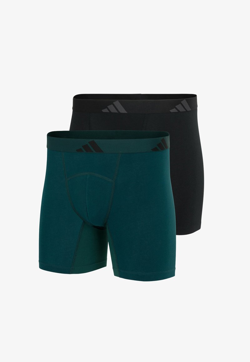 Twee paar herenboxershorts; één in donkerzwart, de ander in groen. Beide hebben een elastische tailleband met merknaam en opvallende strepen.