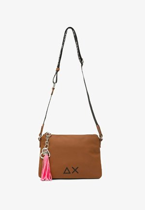 Borsa a tracolla marrone con tracolla nera regolabile, simboli delle lettere greche neri sul davanti e portachiavi con nappina rosa attaccato alla cerniera.