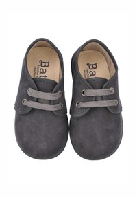 Zapatos de ante gris con puntera redonda, que presentan dos cordones grises y un borde cosido. El logo interior dice "Batihecho", mostrando un diseño sencillo.