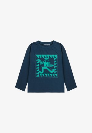 Námořnické tričko s dlouhým rukávem z bavlny, které obsahuje tyrkysový grafický design stylizované postavy uvnitř geometrického rámečku s trojúhelníkovými akcenty.