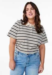 Polo à rayures beige et noir avec manches courtes et col, associé à un jean taille haute bleu clair.
