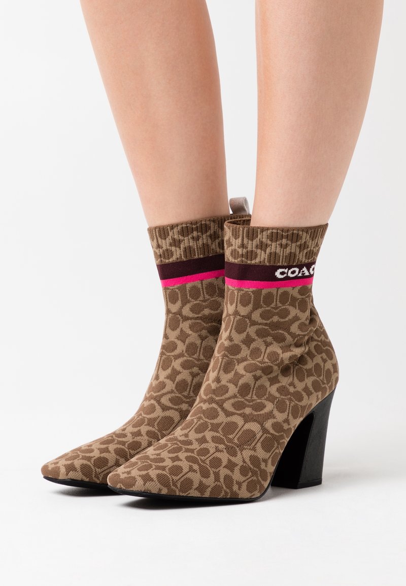 Bottines à motif léopard avec tige tricotée marron, tissu texturé, bord côte et talon bloc à finition noire.