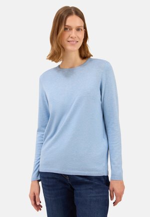 Pull bleu clair à manches longues en matériau tricoté doux, avec un col rond et des poignets côtelés, associé à un jean bleu foncé.