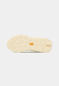 Vibram sole with traction pattern, light beige color, and soft texture. Rounded toe and midsole cushioning detail present.