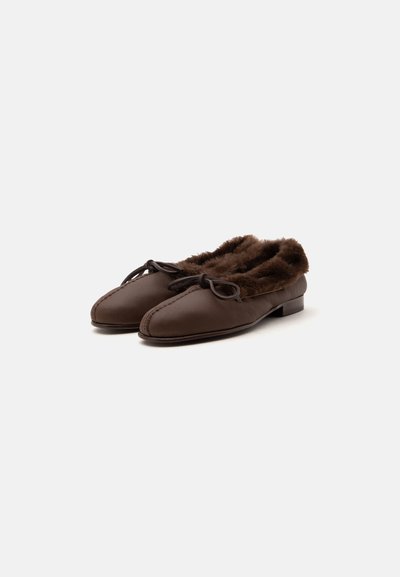 Chaussures en cuir marron à enfiler avec doublure en fourrure et petit nœud, talon bas, présentées sur fond blanc.