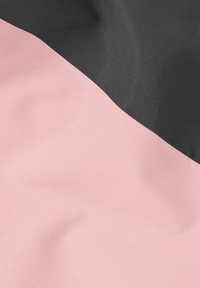 Stoff mit diagonaler Teilung: die untere Hälfte in sanftem Rosa und die obere Hälfte in strukturiertem Schwarz, zeigt Glätte und einen leichten Glanz.
