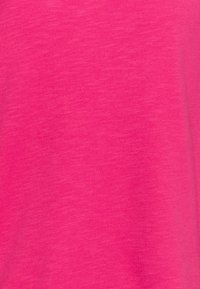 Tela de un rosa brillante con una textura suave. El material presenta un sutil patrón jaspeado, con variaciones en el tono a lo largo de la superficie.