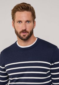Maglione a maglia blu navy con strisce bianche orizzontali, colletto a girocollo e finitura testurizzata. Presenta polsini e orlo a costine.