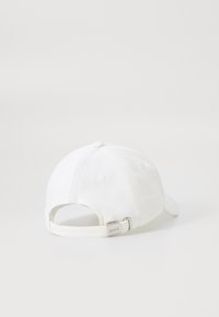 Fehér baseball sapka, amely pamutból készült, ívelt napsütésvédővel, állítható pánttal és ezüstszínű fém kiegészítőkkel, valamint logós címkével a hátsó részen.