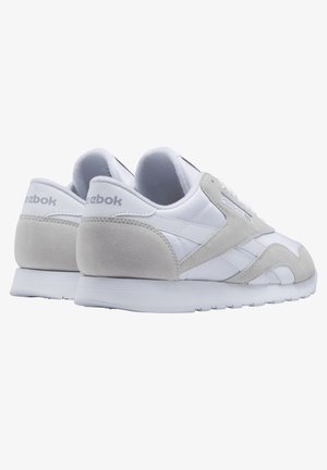Bílé a světle šedé tenisky z kůže a semiše, s designem na šněrování, logovými detaily a texturovanou gumovou podrážkou.